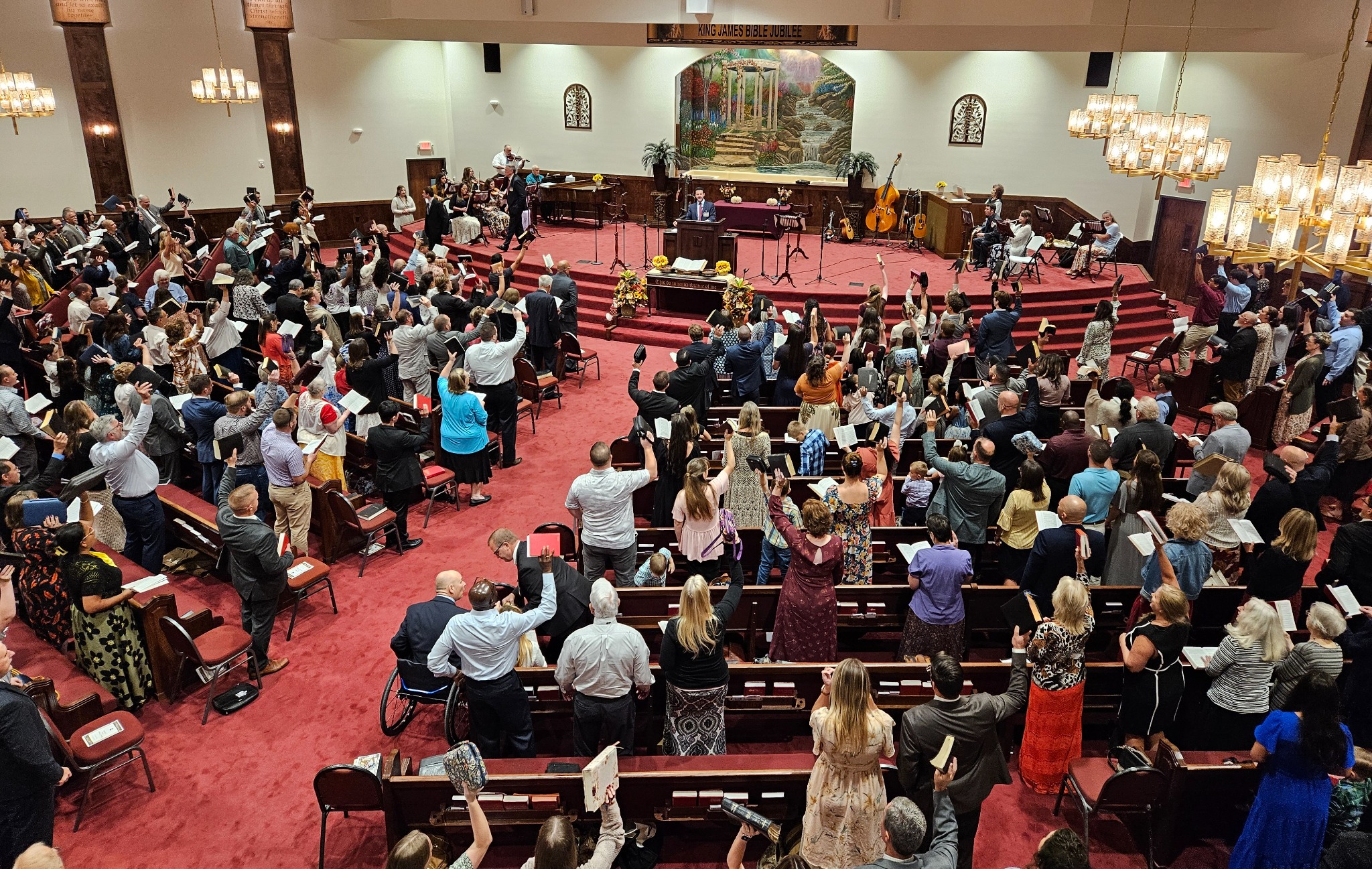 Congregation holding Bibles during the King James Bible Jubilee